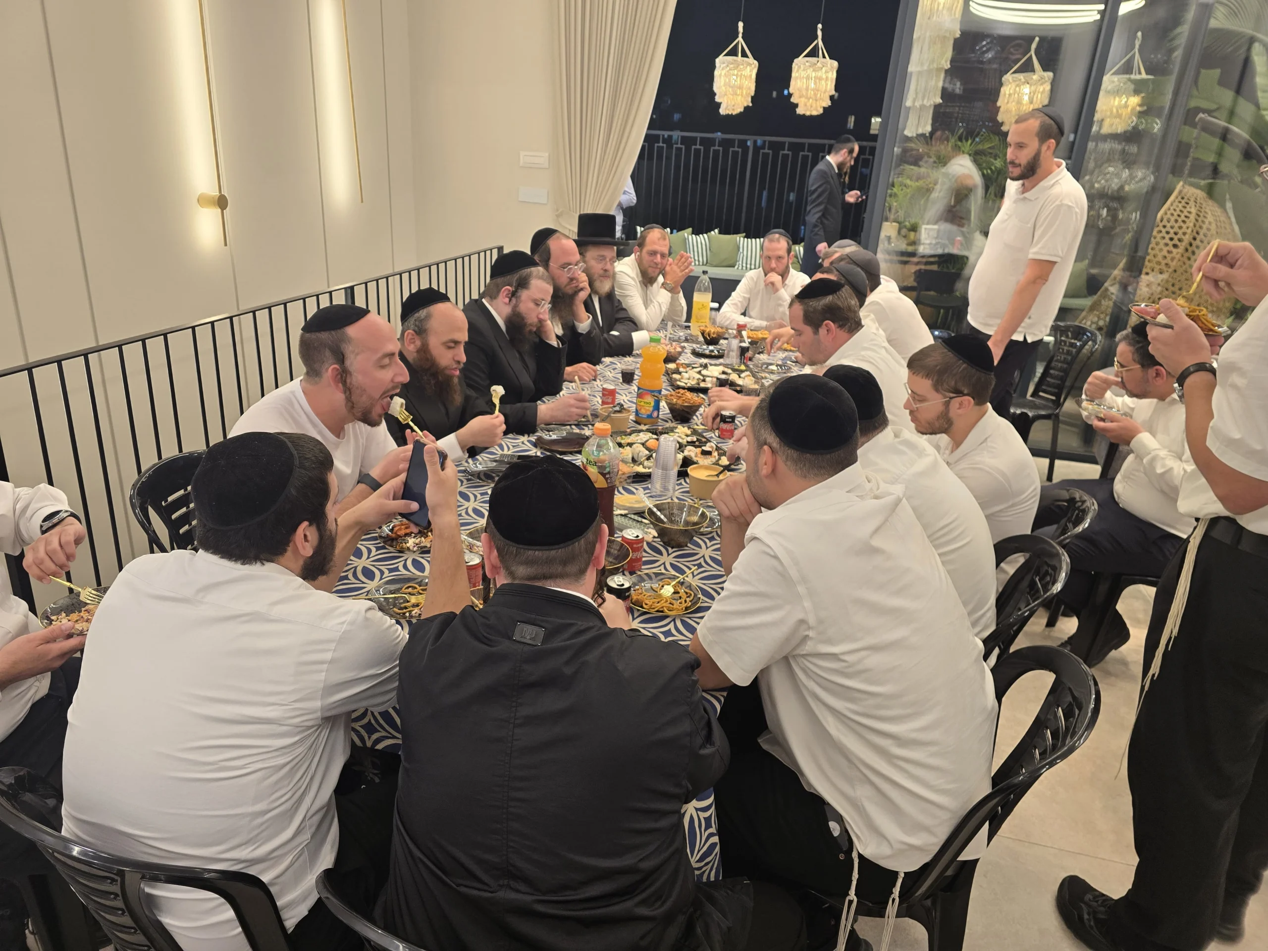 משתתפי המפגש של קהילת 'קדושת לוי' סביב השולחנות